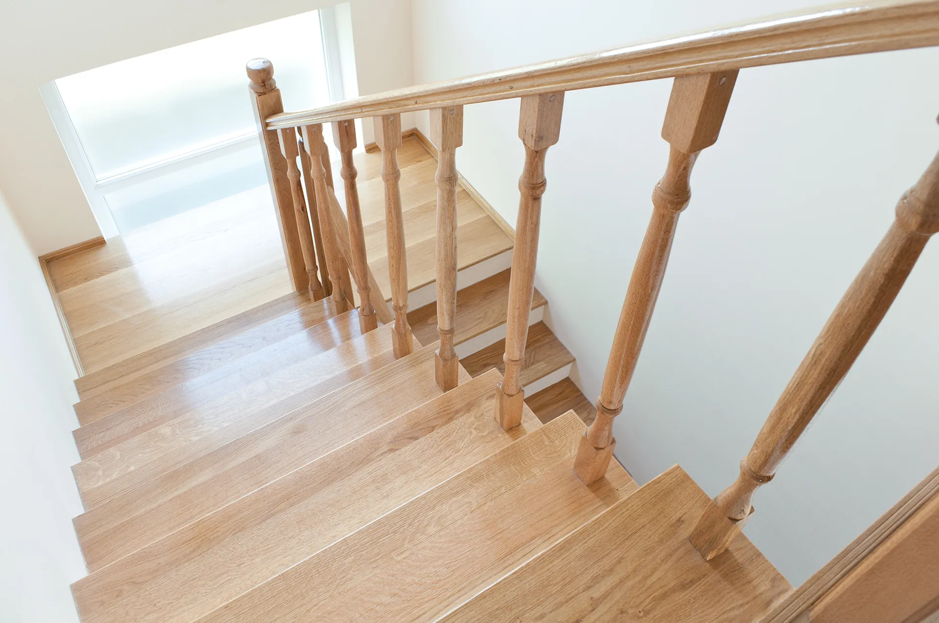 new timber staircase in well illuminated home stairwell